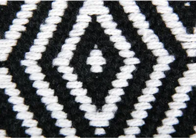 A close-up view of a black and white diamond pattern woven fabric.