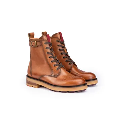 A pair of brown leather lace-up boots with a buckle detail and red accents on the inside of the ankle opening, presented on a white background.