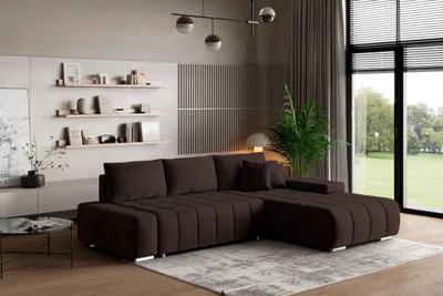 A modern living room with a large sectional sofa, shelves with decor, and a large window with a view of greenery.