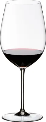 A clear studio shot of a wine glass filled with red wine.