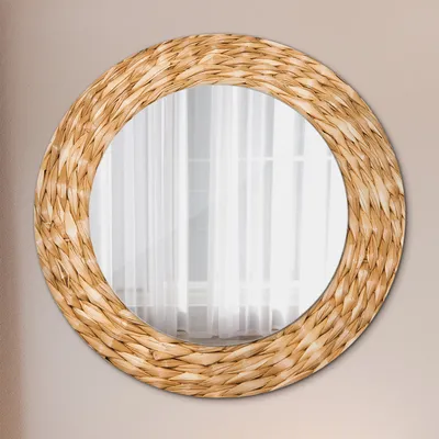 A round mirror with a woven frame hangs on a light-colored wall.