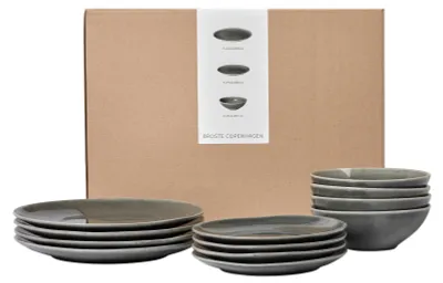 A set of ceramic plates and bowls in a cardboard box.