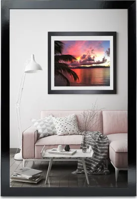 A living room scene featuring a pink sofa, a coffee table with decorative items, and a framed picture on the wall.