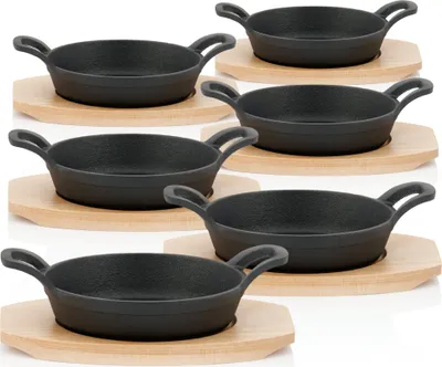 A set of six cast iron serving pans with wooden bases, arranged in three rows on a white background.