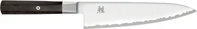 A close-up, side view of a chef's knife against a white background.