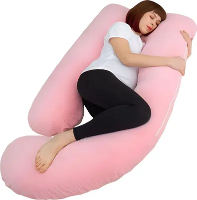 A pregnant woman is sleeping on a large pink U-shaped pillow.