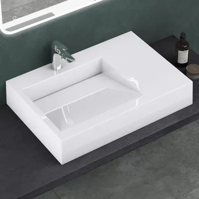 A white rectangular washbasin with a modern faucet is shown on a dark gray countertop.