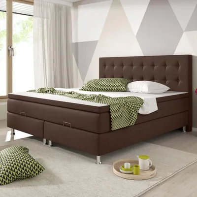 A brown boxspring bed with a tufted headboard is shown in a bedroom setting.