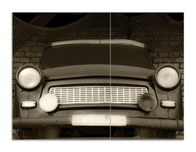 Produktbild von Wallario Herdabdeckplatte aus Glas, Größe 70 x 52 cm 2-teilig, Motiv Alter Trabbi in schwarz-weiß - Frontansicht Scheinwerfer