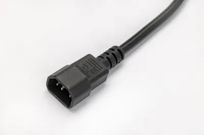 A close-up shot of the female end of a black power cord with a white background.