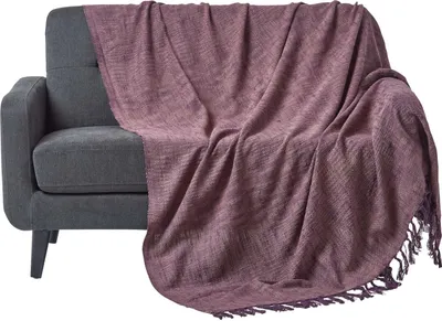 A mauve throw blanket draped over a gray sofa.