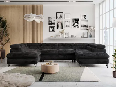 A modern living room with a large U-shaped sectional sofa, coffee table, and decorative wall art.