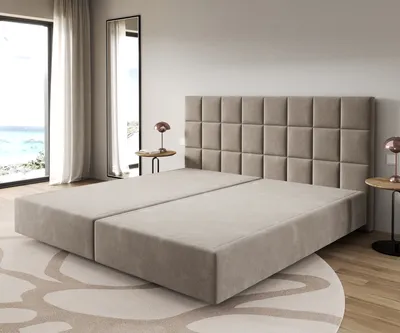 A modern bedroom with a large bed and a view of the ocean through the window.