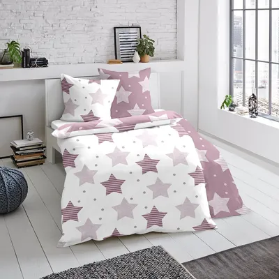 A bedroom scene with a bed made up with star-patterned bedding.