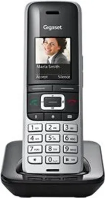 A cordless phone handset is shown in its charging cradle against a white background.