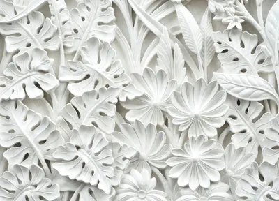 A close-up, detailed view of a white embossed decorative panel featuring a pattern of tropical leaves and flowers.