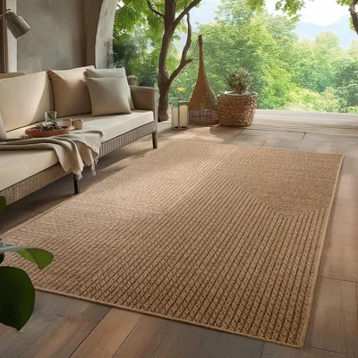 An outdoor patio with a sofa, rug, and plants, overlooking a lush green landscape.