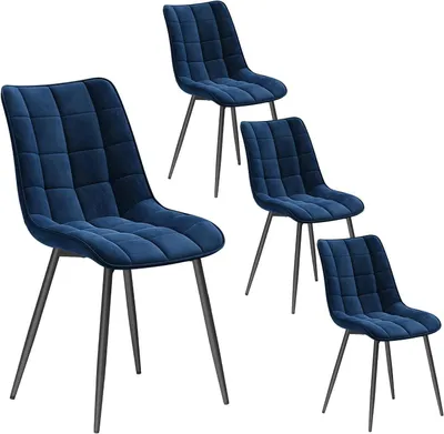 Four blue velvet dining chairs with black metal legs are arranged on a white background.