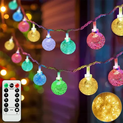 A string of colorful globe lights with a remote control in the foreground.