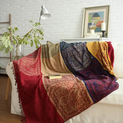 A colorful, patterned throw blanket draped over a white sofa in a living room setting.