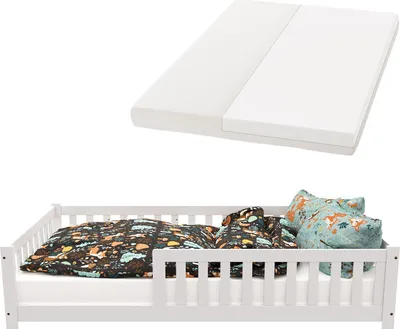 A white children's bed with bedding and pillows, and a separate mattress shown above.