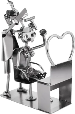 A metal figurine of a hairdresser and client, made from nuts, bolts, and other hardware.
