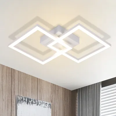 A modern white ceiling light fixture with interlocking square shapes, mounted on a white ceiling.