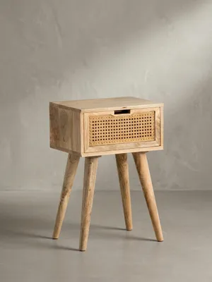 Freigestellte Frontalansicht der Nachtkonsole aus massivem Mangoholz, die schlanke Silhouette mit ausgestellten Beinen und die Schublade mit Wiener Geflecht zeigend._#sku_SAFWL6.807#