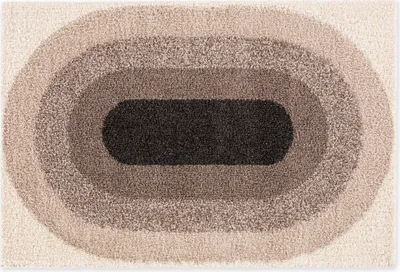 A rug with an oval pattern in concentric rings of different shades of cream, gray, and brown.