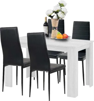 A dining table with four chairs, a bottle of wine, and a vase of flowers.