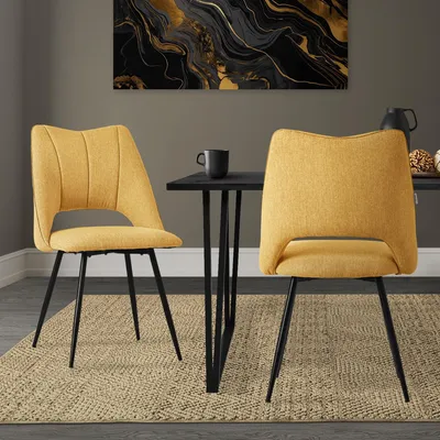 Two yellow dining chairs are placed around a black dining table in a room with a rug and wall art.