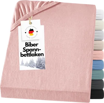 A pink fitted sheet is folded and displayed with a product tag attached.