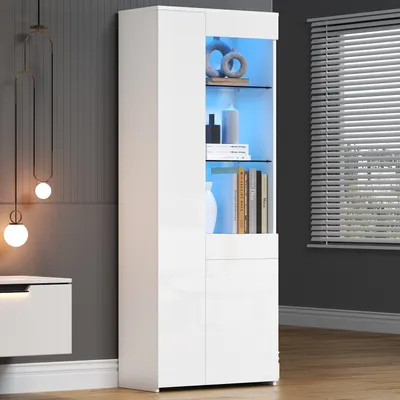 A white high-gloss display cabinet with LED lighting is shown in a room setting, next to a wall with decorative pendant lights and a low cabinet.