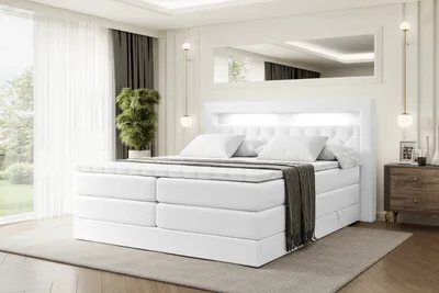 A white boxspring bed with a tufted headboard and LED lighting is shown in a modern bedroom setting.
