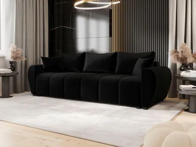 A modern living room with a black sofa, decorative elements, and curtains.