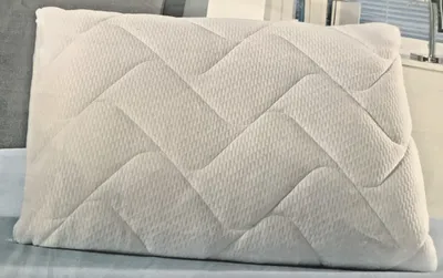 A close-up shot of a white pillow with a quilted pattern.