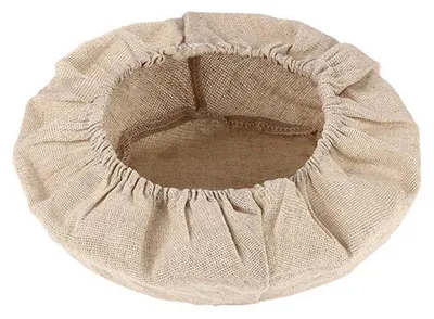 A top-down view of a round, beige, fabric basket with a drawstring closure.