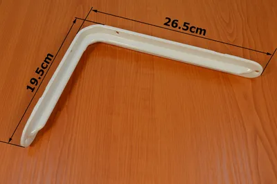 A white shelf bracket is shown on a wooden surface.