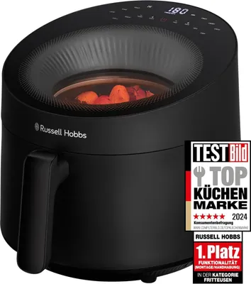 A black Russell Hobbs air fryer with food inside, shown from a slightly angled front view, with a marketing badge on the right side.
