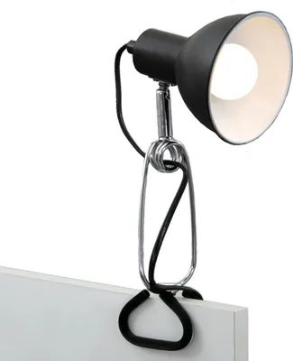 A black desk lamp with a silver clamp is attached to a white surface.