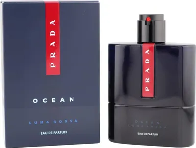 Dunkelblauer Flakon des Prada Luna Rossa Ocean Parfums neben passender Box mit rotem Prada-Streifen.