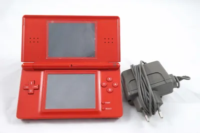 A red Nintendo DS Lite handheld game console and its charger are displayed on a white background.