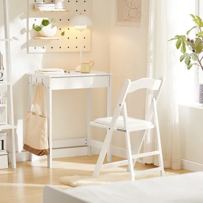 A white desk and chair set up in a bright, minimalist room with natural light.