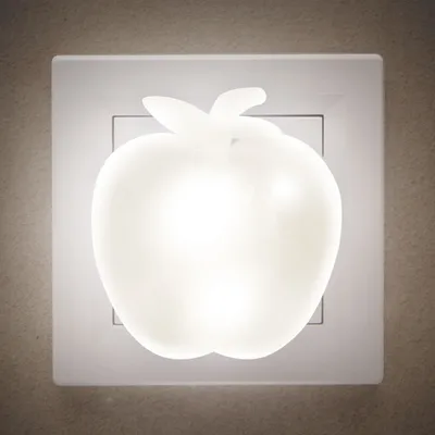 A white apple-shaped night light plugged into a wall socket.