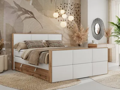 A bedroom scene featuring a large bed with white upholstered headboard and side panels, complemented by wood accents. The room is decorated with abstract wallpaper, pendant lights, and dried floral arrangements.