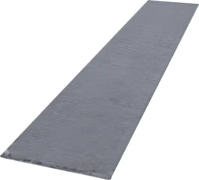A long, narrow, dark gray rug with a high pile texture is shown from a diagonal angle against a white background.