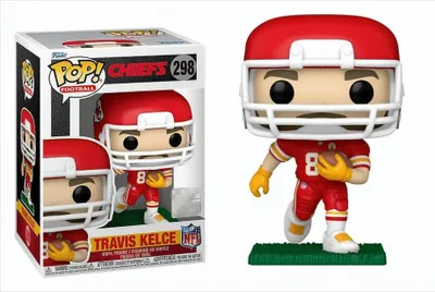 A Funko Pop! figure of Travis Kelce in his Kansas City Chiefs uniform, shown both in its packaging and displayed on a green base.