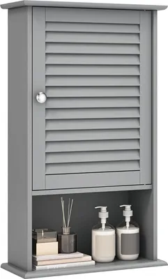 A gray bathroom wall cabinet with a louvered door and an open shelf below, displaying toiletries and decorative items.