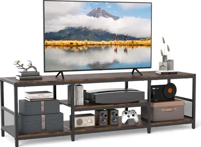 A TV stand with a television and various electronic devices and decorative items.