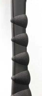 A close-up view of a black textured grip on a dark cylindrical object, likely a handle or part of a device.
